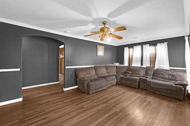 living room with ceiling fan, a textured ceiling, dark hardwood / wood-style floors, and crown molding