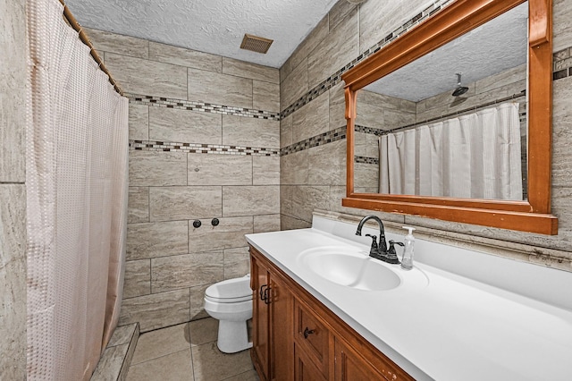 bathroom featuring toilet, vanity, tile patterned floors, a textured ceiling, and a shower with shower curtain