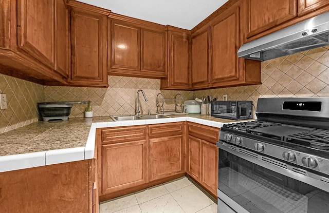 kitchen with extractor fan, sink, backsplash, gas range, and light tile patterned floors