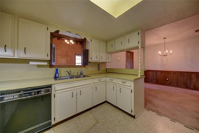 kitchen with wooden walls, dishwasher, a chandelier, pendant lighting, and sink