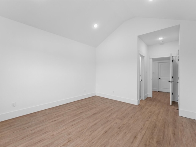 empty room with light hardwood / wood-style flooring and vaulted ceiling