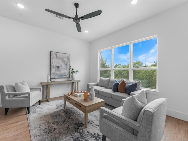 living room with ceiling fan, wood-type flooring, and a healthy amount of sunlight