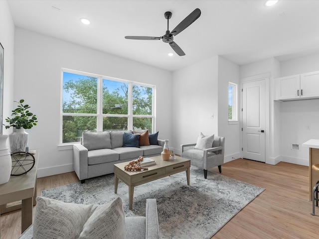 living room featuring ceiling fan, a wealth of natural light, and light hardwood / wood-style floors