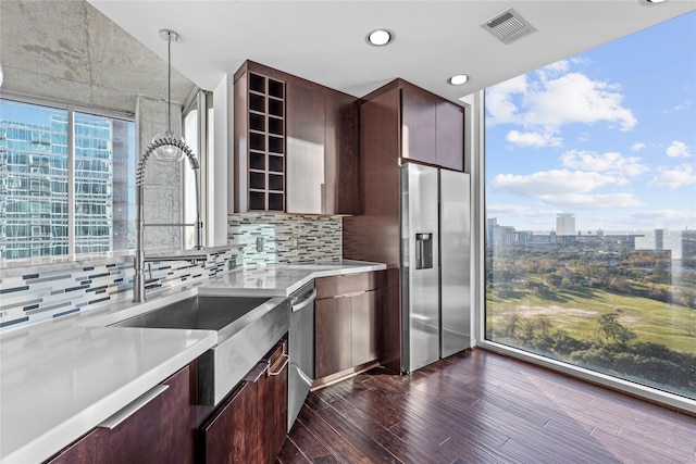 kitchen featuring backsplash, pendant lighting, sink, stainless steel appliances, and dark hardwood / wood-style flooring