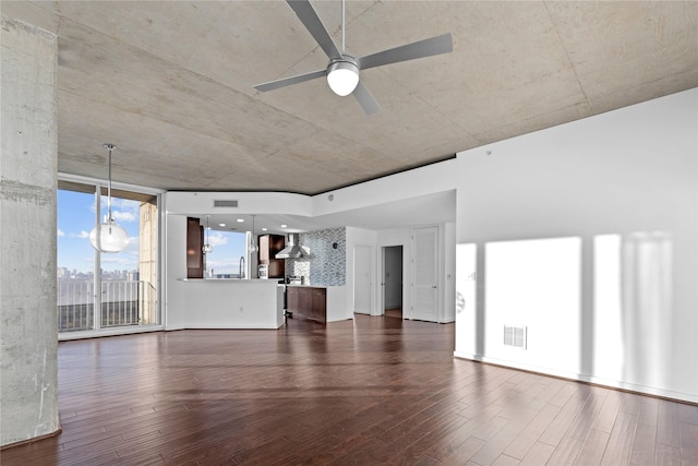 unfurnished living room featuring ceiling fan, dark wood-type flooring, and floor to ceiling windows