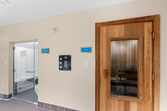 hallway featuring dark tile patterned floors