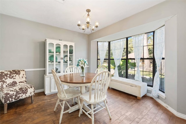 dining space with dark wood-type flooring and a chandelier