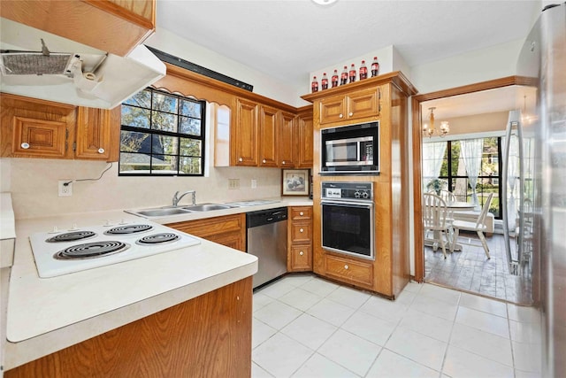 kitchen with light tile patterned floors, stainless steel appliances, sink, and a notable chandelier