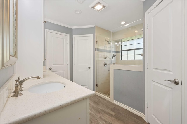 bathroom with vanity, crown molding, hardwood / wood-style floors, and a shower with door