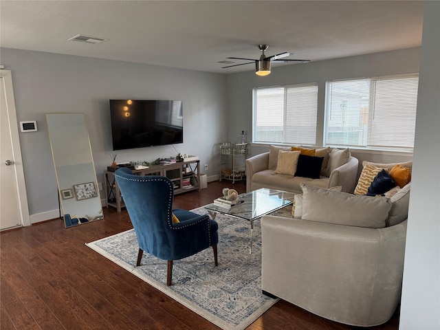 living room with ceiling fan and dark wood-type flooring