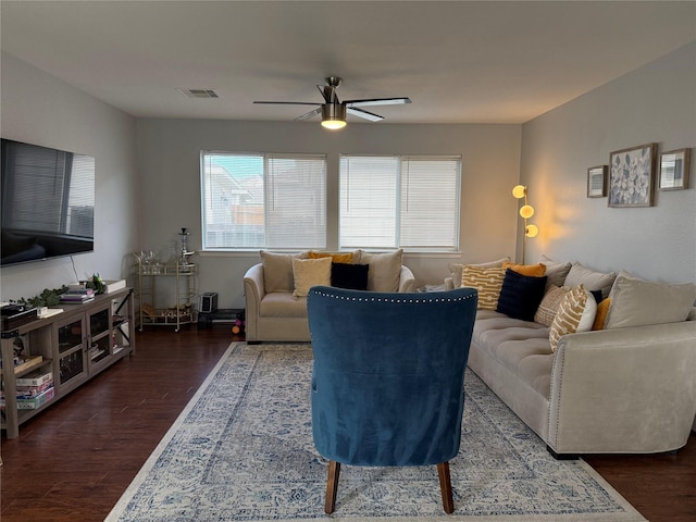 living room featuring ceiling fan and dark wood-type flooring