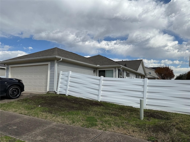 view of home's exterior with a garage and a lawn