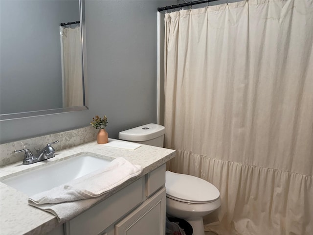 bathroom featuring toilet, vanity, and a shower with curtain