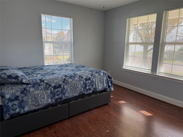 bedroom with dark hardwood / wood-style floors