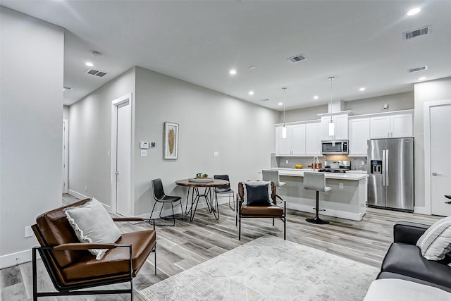 living room featuring sink and light hardwood / wood-style flooring