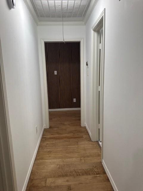 hallway with hardwood / wood-style flooring and ornamental molding