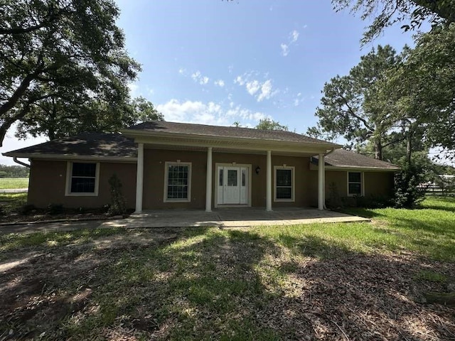 back of property featuring a lawn and a patio