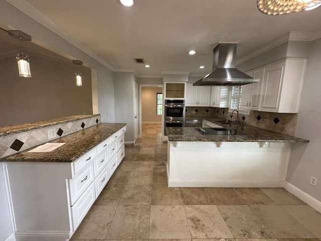 kitchen with kitchen peninsula, dark stone counters, island exhaust hood, and white cabinetry