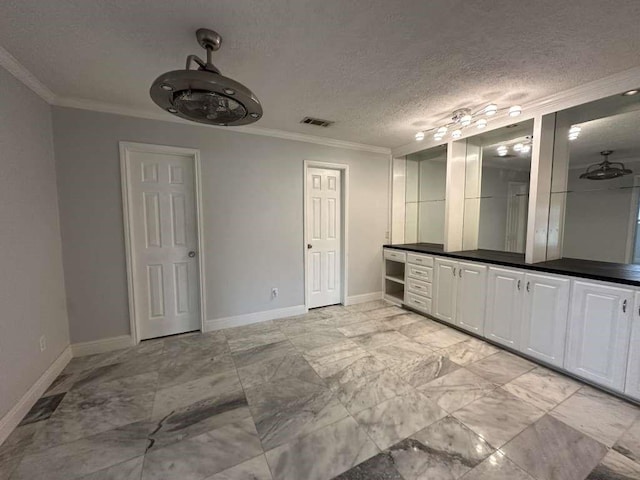 bathroom with a textured ceiling, ornamental molding, and vanity