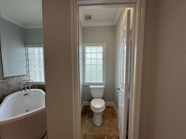 bathroom featuring toilet, a tub, and crown molding