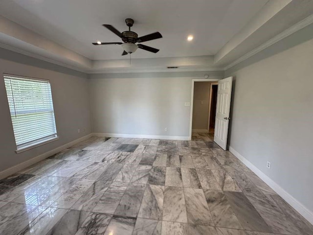 spare room with ceiling fan and a tray ceiling