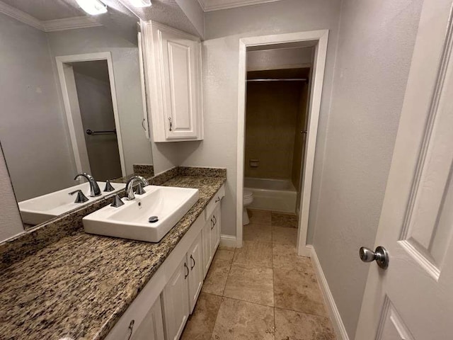 bathroom with toilet, vanity, and ornamental molding