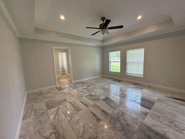 unfurnished room with ceiling fan, ornamental molding, and a tray ceiling