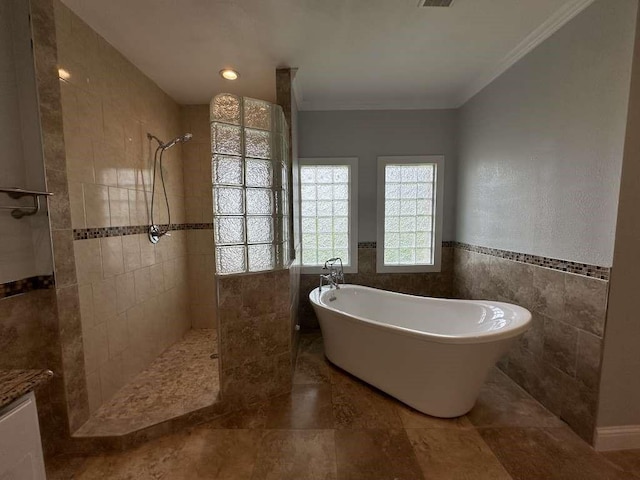 bathroom with tile walls, ornamental molding, and plus walk in shower