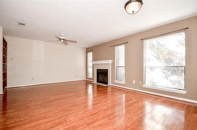 unfurnished living room featuring ceiling fan, plenty of natural light, and light hardwood / wood-style floors