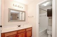 bathroom featuring toilet, vanity, and a shower