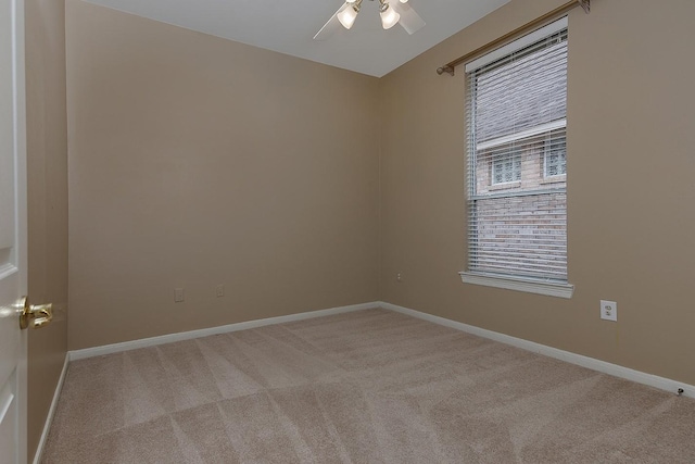 carpeted spare room with ceiling fan