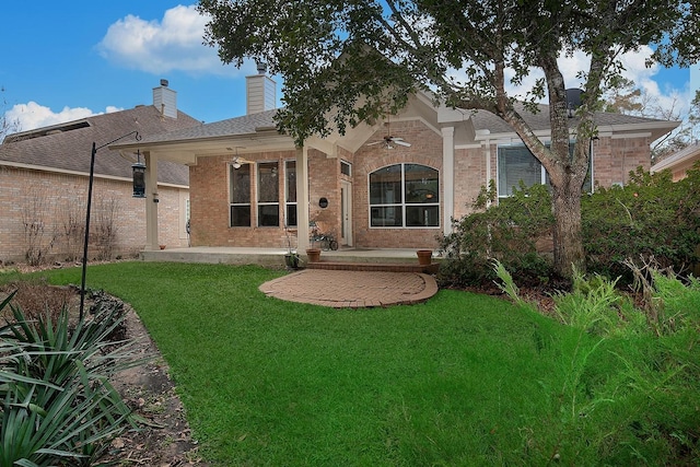 rear view of house with a lawn and a patio area