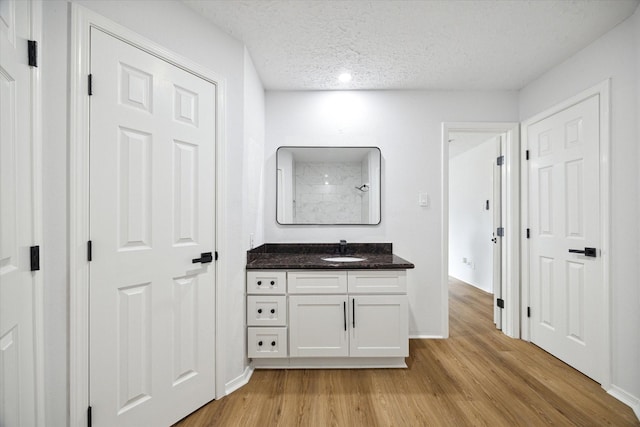 bathroom featuring wood-type flooring, a textured ceiling, and vanity