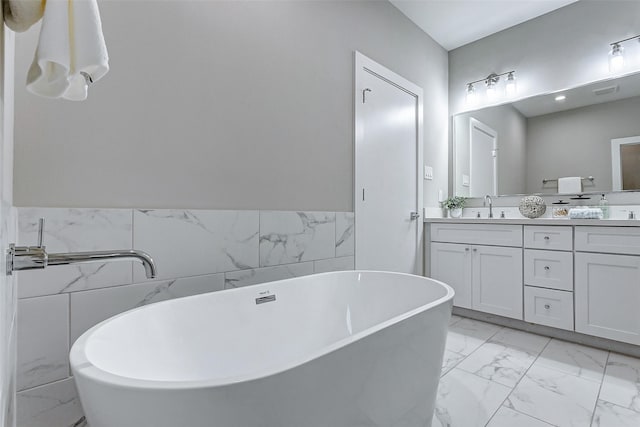 bathroom with vanity, tile walls, and a bath