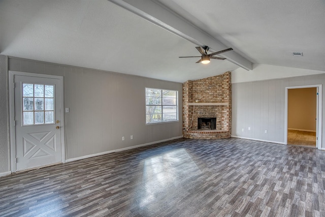 unfurnished living room featuring ceiling fan, dark hardwood / wood-style flooring, a fireplace, and vaulted ceiling with beams