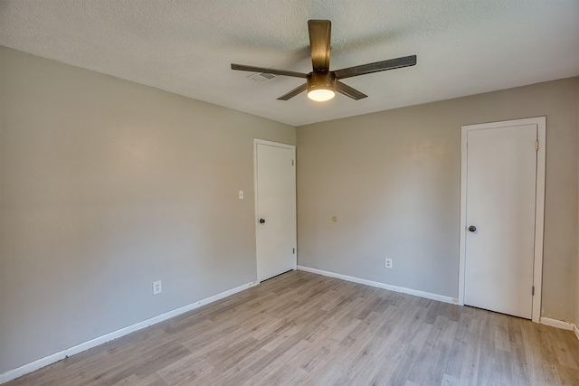 spare room featuring a textured ceiling, ceiling fan, and light hardwood / wood-style flooring