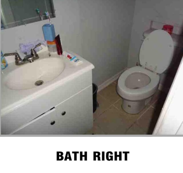 bathroom featuring toilet, vanity, and tile patterned flooring