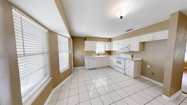 kitchen featuring sink, white appliances, white cabinetry, and light tile patterned flooring