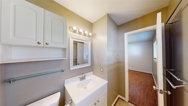 22306 Rustic Bridge Ln, Houston, TX 77339 - half bath featuring toilet, vanity, wood finished floors, and baseboards