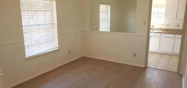 unfurnished dining area featuring sink and light hardwood / wood-style flooring