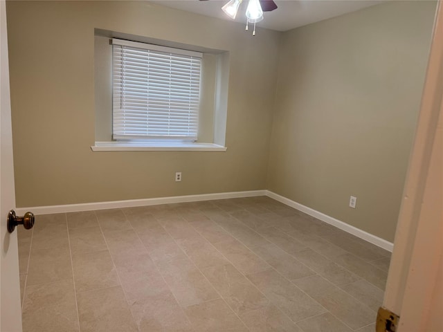 spare room with ceiling fan and light tile patterned floors