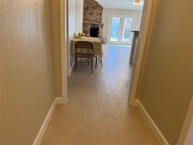 hallway featuring french doors and light tile patterned flooring