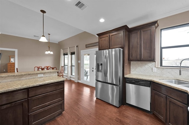 kitchen with decorative light fixtures, backsplash, sink, dark brown cabinetry, and appliances with stainless steel finishes