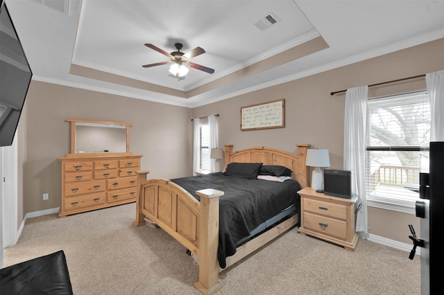 carpeted bedroom with ceiling fan, ornamental molding, and a raised ceiling