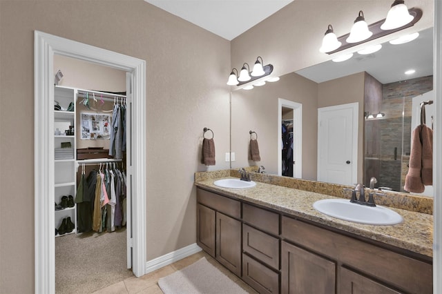 bathroom with tile patterned floors, a shower with shower door, and vanity