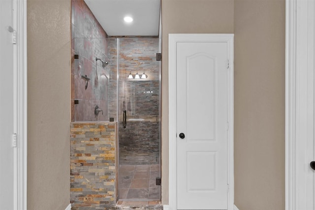 bathroom with a shower with door