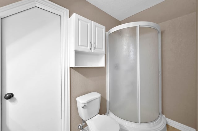 bathroom with a shower with shower door and toilet