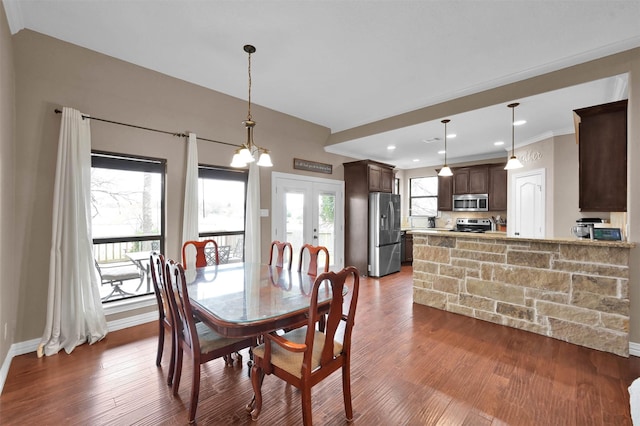 dining room with dark hardwood / wood-style floors, a notable chandelier, and french doors