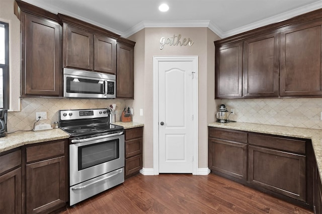 kitchen featuring backsplash, appliances with stainless steel finishes, and dark brown cabinets