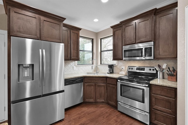 kitchen featuring tasteful backsplash, appliances with stainless steel finishes, sink, and light stone counters